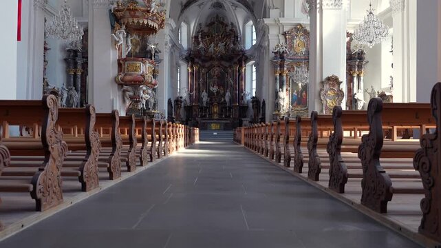 Wide-angle interior footage showing the wooden pews, central aisle, and ornate baroque architecture of the Benedictine Monastery in Einsiedeln.