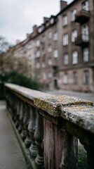 Naklejka premium Weathered stone balustrade along quiet city walkway, soft focus apartment facade in background, moody urban texture for architecture design and autumn atmosphere