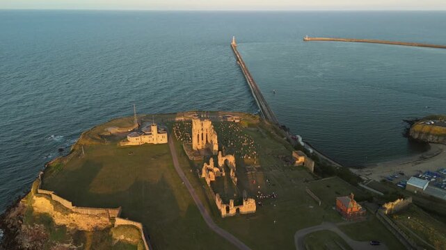 Sunset casts a warm glow over Tynemouth Pier along the North Sea at dusk