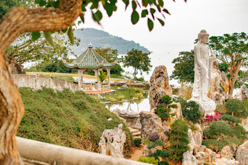 Temple park in Vietnam with lake, Asian style gazebo and Buddha statue