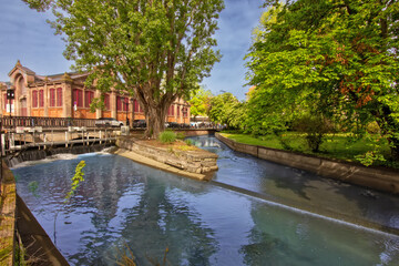 Colorful historic canal houses reflected in quiet water in Colmar.