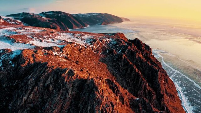 Aerial drone view of Lake Baikal, Siberia, Russia, snow-covered natural scenery, frozen lake and surrounding forests, cold winter climate, panoramic sky, serene nature, clear daylight, January 2025
