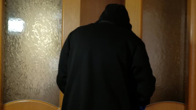 Detailed view of a man practicing karate strikes with bare hands at home. Focus on fist position, strength, and traditional martial arts training.He stands with his back to the ambassador and turns 
