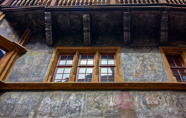 Colorful historic timber house with ornate balcony and medieval architecture in Colmar.