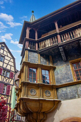 Colorful historic timber house with ornate balcony and medieval architecture in Colmar.