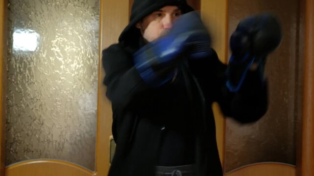 Intense Shadow Boxing Workout at Home for Fitness.An athletic man performing a high-intensity shadow boxing routine in a modern apartment. Focus on fitness, strength, and technique.