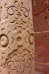 Naklejka premium Close view of carved Gothic church pillar showing medieval faces and stone ornament.