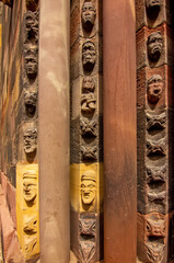 Naklejka premium Close view of carved Gothic church pillar showing medieval faces and stone ornament.