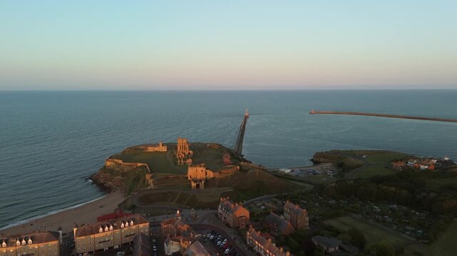 Sunset casts a warm glow over Tynemouth Pier along the North Sea at dusk