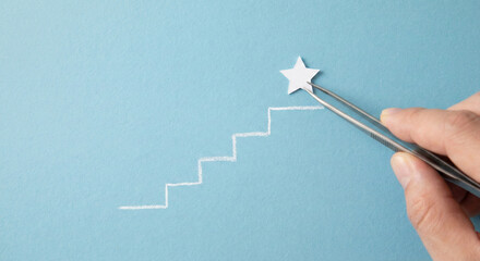 Hand placing star on top of stairs with tweezers