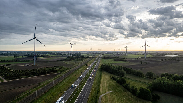 Aerial view of wind turbines and highway in rural Belgium countryside, renewable energy and sustainable infrastructure concept