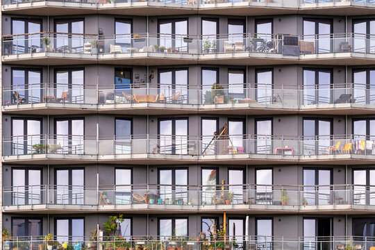 Modern architecture facade of residential apartment building balconies showing repetition in HafenCity district in Hamburg Germany with strong urban housing pattern