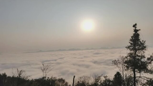 Horizontal time-lapse showing a dynamic cloudscape. Dense clouds rapidly flow across the frame, occasionally obscuring and then dramatically revealing the bright sun behind. A powerful and epic natura
