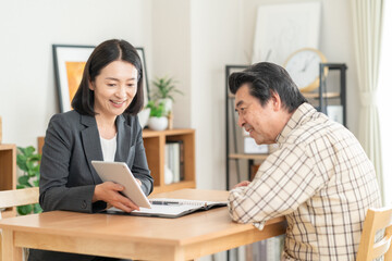 Obraz premium リビングで男性と商談をするビジネスウーマン