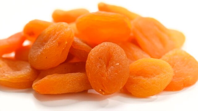 Dried apricots close-up. Apricot dried fruits isolated on white background. Ripe organic apricots fruit rotating. Close up. Heap of dried apricot. Vegan food, fiber. 
