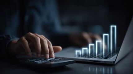 Fototapeta premium Person using calculator and laptop with digital growth bar chart