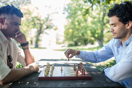 Two men playing game of chess in park