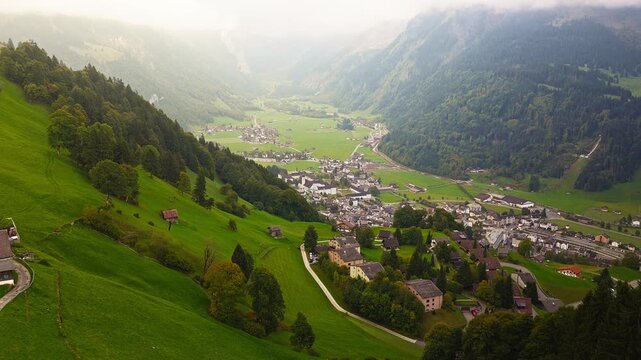 Cinematic drone shot of alpine Swiss village with mountains, 4K