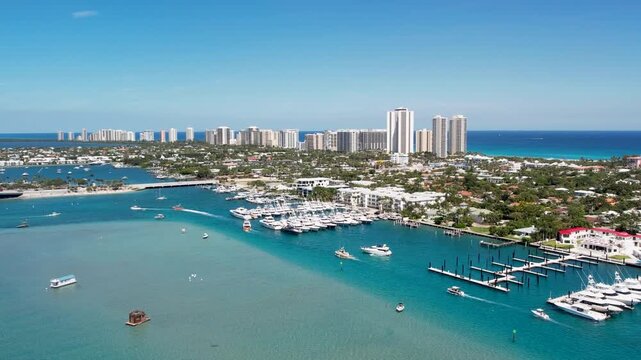 Aerial view of boats traversing the clear turquoise waters near the marina and city buildings, West Palm Beach, Florida, United States.