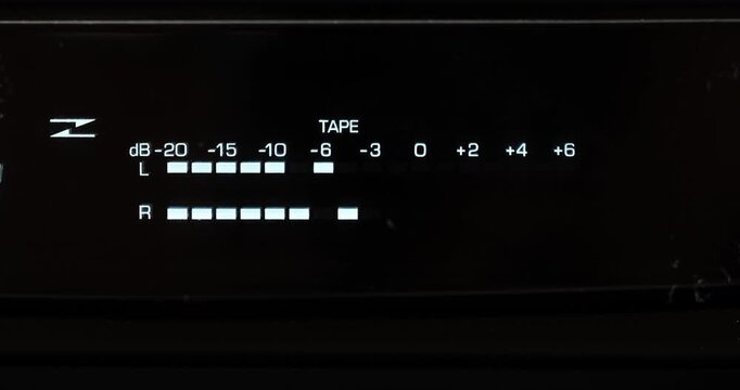 A macro close-up view of a digital VFD audio volume level meter or VU meters. Real time video, pulsating display