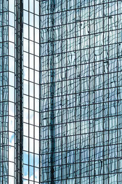 Glass facade windows on a modern corporate office skyscraper showing reflection across building architecture with abstract exterior pattern design