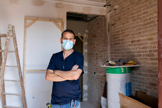 Portrait of a man wearing protective face mask in a house under construction