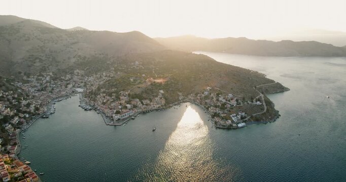 Aerial view of the picturesque Simi town nestled by the coast, where the terracotta roofs meet the turquoise waters of the Aegean Sea, Simi, Rhodes, Greece.
