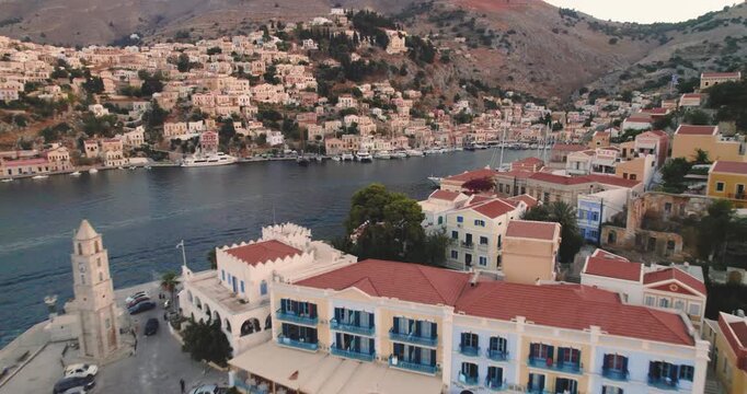 Aerial view of the harbour with boats nestled between the town and the mountains, creating a stunning contrast, Simi, Rhodes, Greece.