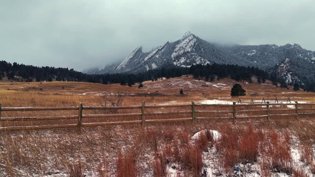 Winter Chautauqua Park Flat Irons Mountain snowing snow flakes snowfall aerial drone Colorado USA dusk sunset low clouds grass snow covered Rock formation walking loop trail Bear Peak static shot