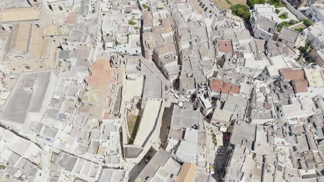 Aerial view of the white buildings of Ostuni with a church dome and narrow streets creating a maze-like pattern, Ostuni, Apulia, Italy.