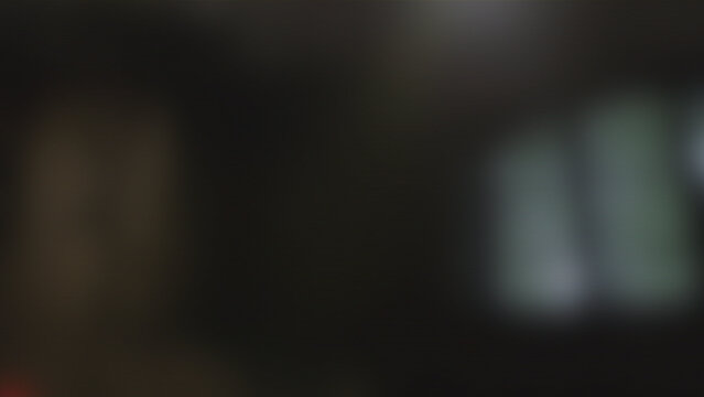 Dark blurry background with soft bokeh lights and moody atmosphere for cinematic overlays or professional video backdrops