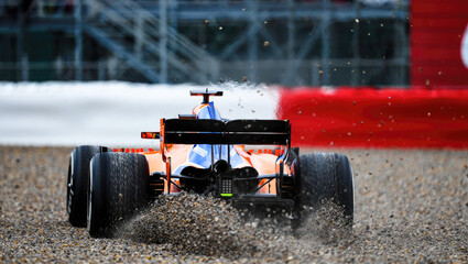 Naklejka premium Race car spinning in gravel trap during motorsport event on track, gran prix, back view, going off-road 