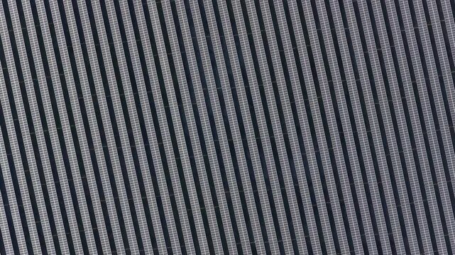 Aerial view of a vast array of solar panels displaying a geometric pattern of alternating light and dark tones, Wittelsheim, Grand Est, France.