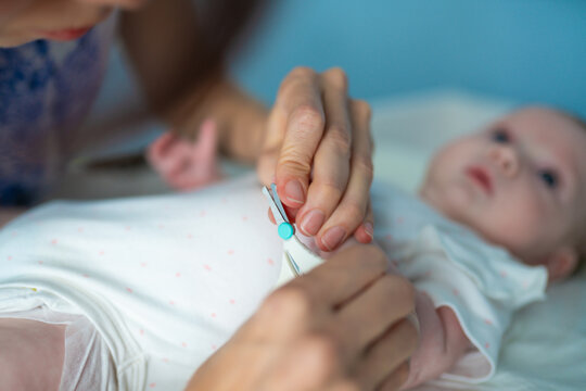 Mother trims her infant baby nails, creating a safe and comfortable environment for care