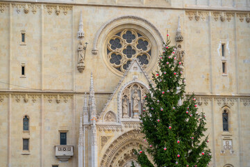 Architectural detail of Zagreb Cathedral decorated with a Christmas tree during winter season. Combination of religious heritage and festive atmosphere in the city center