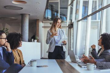 Professional Woman Leads Business Meeting Presentation With Tablet In Modern Office Conference Room