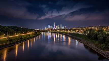Nighttime cityscape with illuminated buildings reflecting in calm river water