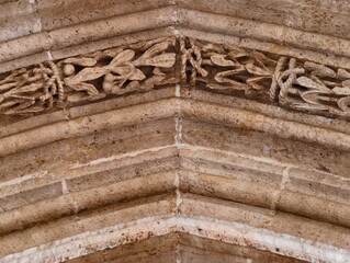 Image of aged arch, Photograph depicting old limestone arch with elaborate foliage engravings and textures © Vladimir