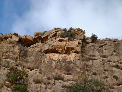 Majestic limestone formation stretching skyward with exposed layers and limited plant life