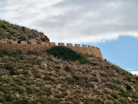 Old fortress on ridge, Ancient stone citadel located on ridge displaying battlements and weathered masonry
