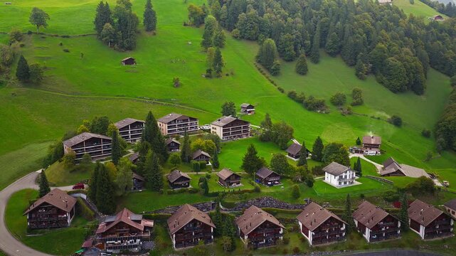 Cinematic drone shot of alpine Swiss village with mountains, 4K