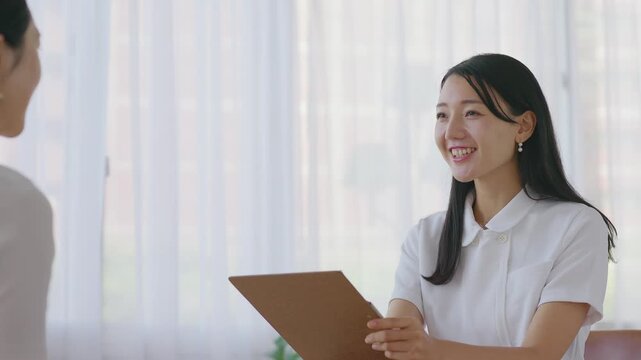 Woman in white coat taking notes during consultation