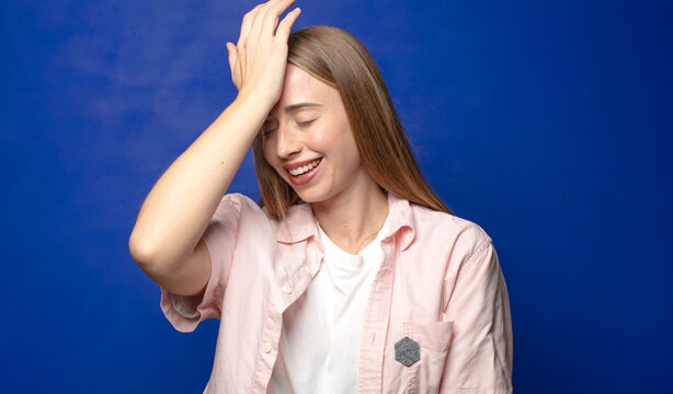 laughing and slapping forehead like saying d&rsquo;oh! I forgot or that was a stupid mistake
