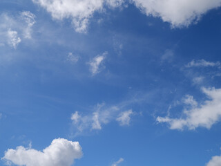 Obraz premium ​Bright blue sky framed by fluffy white cumulus clouds on a clear sunny day. Perfect for nature, weather, and inspirational backgrounds