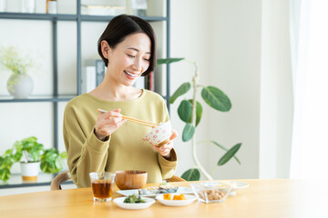 家で朝ごはんを食べるミドルの女性