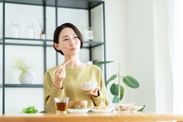 家で朝ごはんを食べるミドルの女性