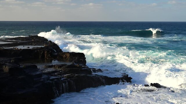 Cinematic aerial of massive Atlantic waves crashing on Gran Canaria coast with dangerous swell and red flag sea conditions
