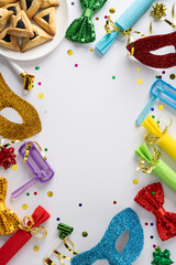 Naklejka premium Vibrant vertical Purim tableau featuring glitter masks, bright ribbons, a blue noisemaker, wrapped gifts, scattered confetti, and plate of hamantaschen cookies