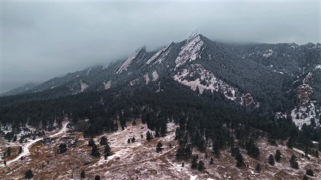 Flat Irons Mountain Winter Chautauqua Park aerial drone Colorado USA snowing snow flakes snowfall dusk sunset low clouds grass snow covered Rock formation walking loop trail Bear Peak circle right