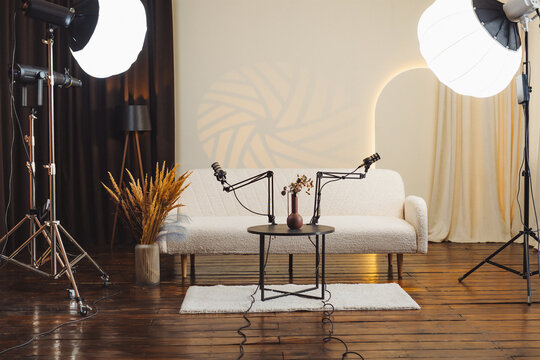 Podcast setup in a studio for interviews about education with microphones and lighting on a wooden floor